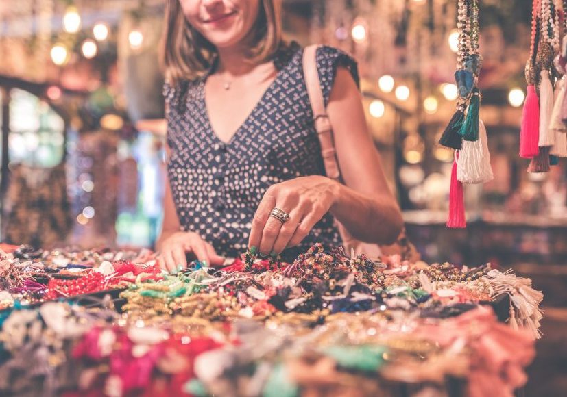 Femme devant un stand de colliers
