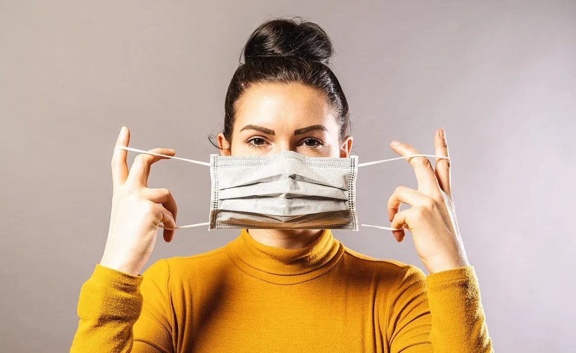 Femme mettant un masque sur son visage