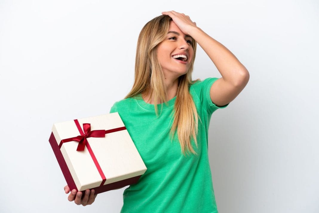 Young Uruguayan woman holding a gift isolated on white background has realized something and intending the solution