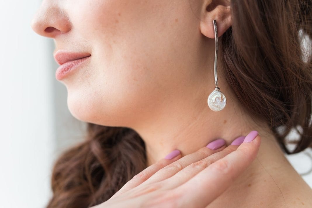 Close-up portrait of beautiful young woman with elegant hairstyle and luxurious jewelry and bijouterie.